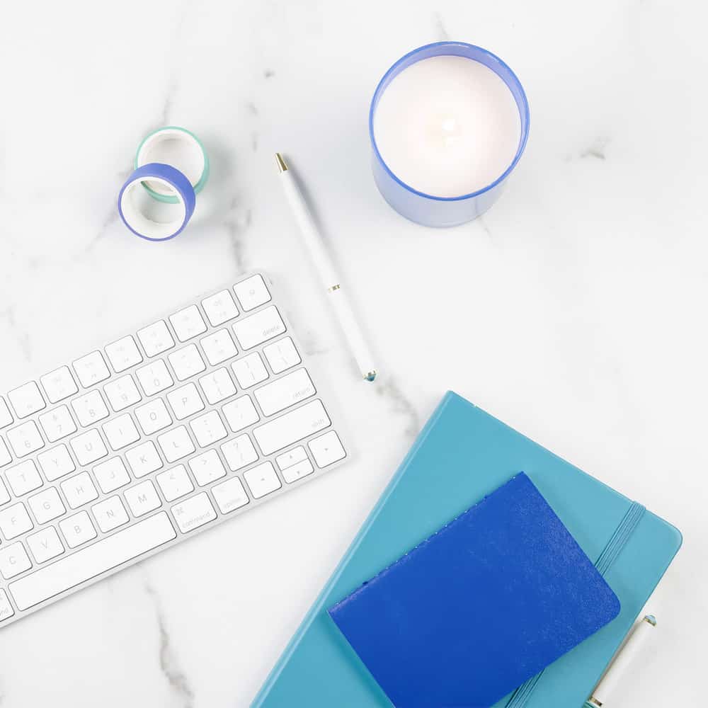 White laptop keyboard with blue notebooks to record SEO notes