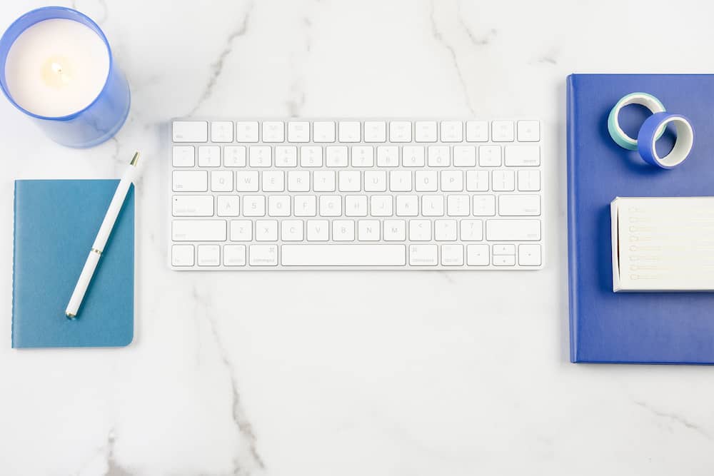 Marble desk with white keyboard and blue accents